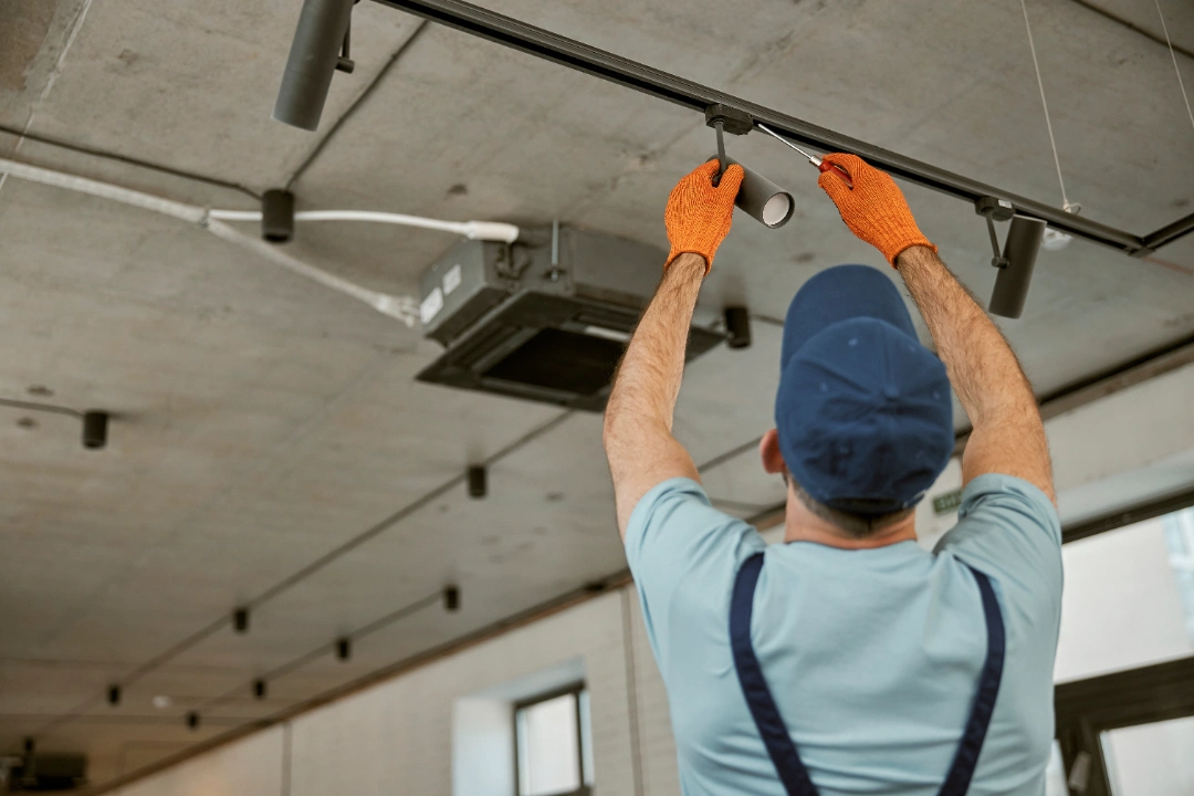 Electrician fixing ceiling lamp