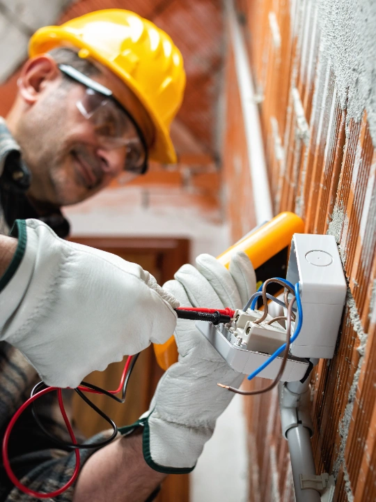 Electrician using a tool to check outdoor plug